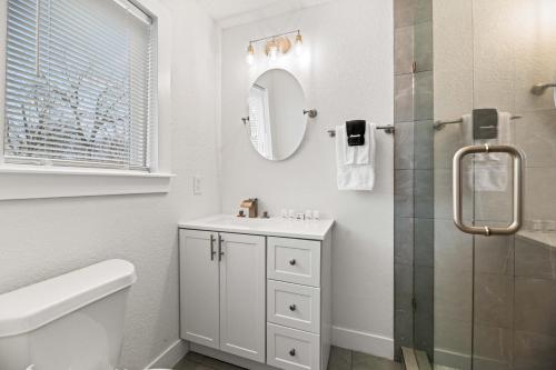 a white bathroom with a sink and a shower at Spacious McKinney Bungalow - 4 Bedrooms in McKinney