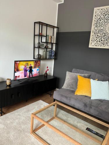 a living room with a couch and a tv at Moderne Wohnung Kerpen in Kerpen