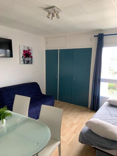 un salon avec une table et un meuble bleu dans l'établissement appartement 50 m plage st Jean de Monts, à Saint-Jean-de-Monts
