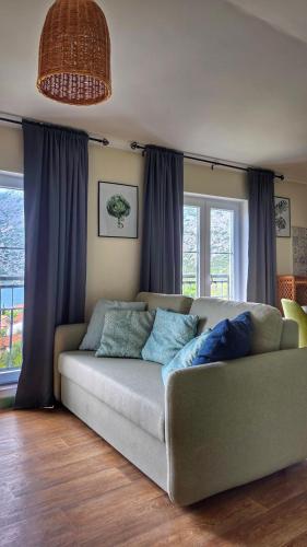a living room with a couch with blue pillows at Apartment Mint&Rose in Risan