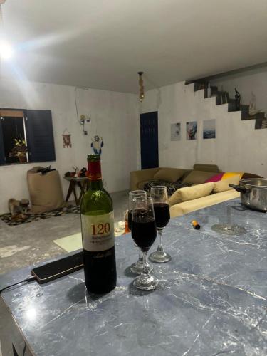 a bottle of wine and two glasses on a table at Casa de Veraneio in Caucaia