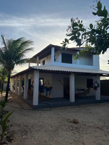 a house with a hammock in front of it at Casa de Veraneio in Caucaia