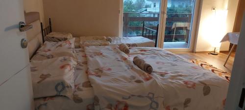 two twin beds in a room with a window at Villa Nathanael Cozy Rooms with Balcony in Pogradec