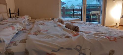 a room with three large beds with white sheets at Villa Nathanael Cozy Rooms with Balcony in Pogradec