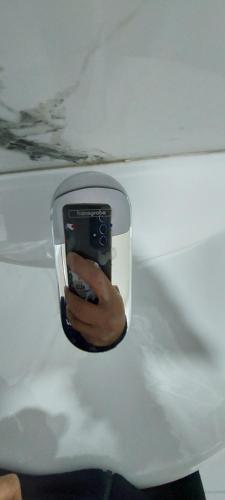 a person holding a cell phone in a mirror at Villa Nathanael Cozy Rooms with Balcony in Pogradec