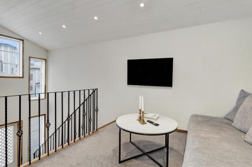 a living room with a couch and a tv on a wall at HernöRum Storgatan - Centrala lägenheter in Härnösand
