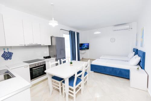 a room with a kitchen and a bed and a table at CAPTAIN'S RESIDENCE in Ksamil