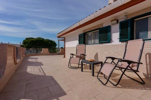 two chairs and a table on a patio at B&B DANIELA! in Leporano Marina