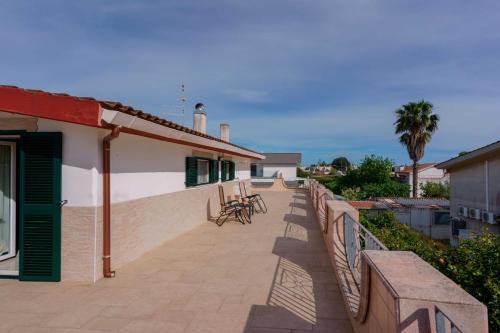 a balcony of a house with tables and chairs at B&B DANIELA! in Leporano Marina