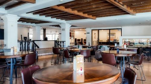 a restaurant with tables and chairs and a bar at InHouse Hotel Obregón in Ciudad Obregón