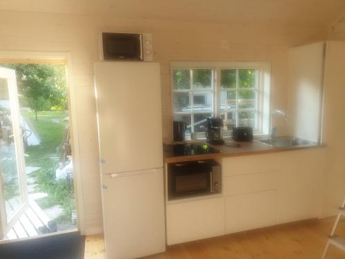 a kitchen with a white refrigerator and a window at Newly built house at central location in Strängnäs in Strängnäs