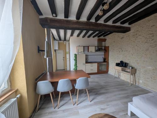 une cuisine avec une table et des chaises dans une pièce dans l'établissement Studio centre ville, à Bellême