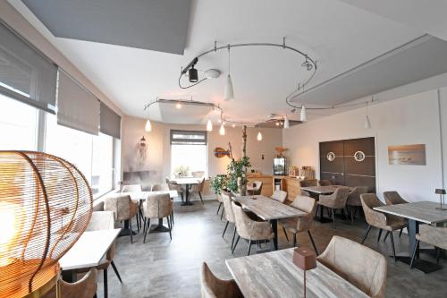 un restaurant avec des tables et des chaises dans une salle dans l'établissement Cit'Hotel La Villa Julia, à Agon-Coutainville