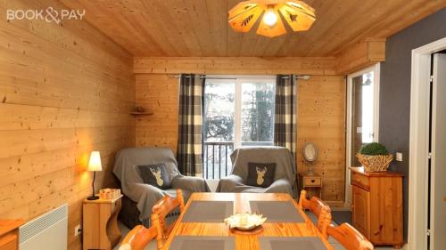 un salon avec une table et deux chaises dans l'établissement La Belle Vue Gérardmer, à Gérardmer