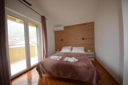 a bedroom with a bed with two towels on it at Apartman Milošević in Kotor