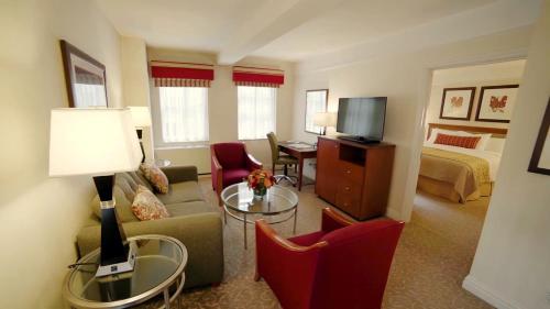 a living room with a couch and a room with a bed at San Carlos Hotel New York in New York