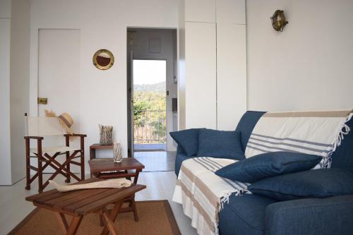 Una sala de estar con un sofá azul y una mesa. en Merveilleux, sur la plage et accès direct à la mer, en Olmeto