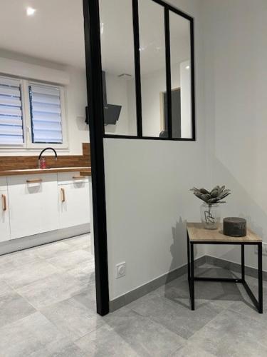 - une cuisine avec une table et un miroir mural dans l'établissement Charmante maison de plain pied, à Chandai