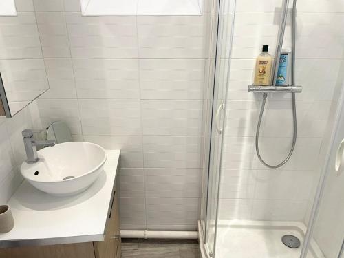 a white bathroom with a sink and a shower at Studio lumineux et calme - Netflix, CHU et métro 14 in Le Kremlin-Bicêtre