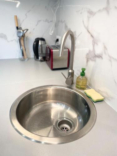 a silver sink in a kitchen with a toaster at Studio lumineux et calme - Netflix, CHU et métro 14 in Le Kremlin-Bicêtre