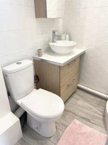 a bathroom with a white toilet and a sink at Studio lumineux et calme - Netflix, CHU et métro 14 in Le Kremlin-Bicêtre