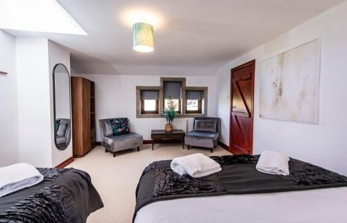 ein Schlafzimmer mit zwei Betten und ein Wohnzimmer in der Unterkunft Beautiful Cottage, stunning views, Hot Tub, Sleeps 10! in Todmorden