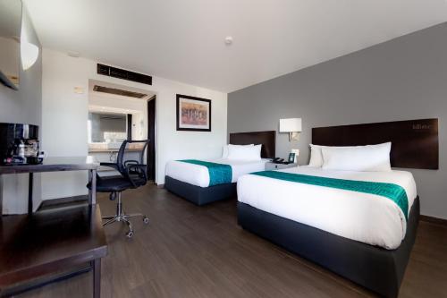 a hotel room with two beds and a desk at InHouse Hotel Obregón in Ciudad Obregón