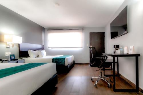 a hotel room with two beds and a desk and a chair at InHouse Hotel Obregón in Ciudad Obregón