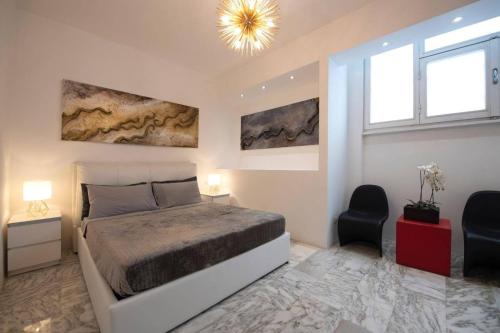 a bedroom with a bed and two chairs and a chandelier at La Galleria in Milan