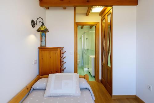 a small room with a bed and a bathroom at El Jardín de Casa Male in Pimiango