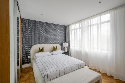 a bedroom with a white bed and a window at Luxurious City Centre Apartment in Chelmsford with Sky TV, Sports, Movies & Netflix in Chelmsford