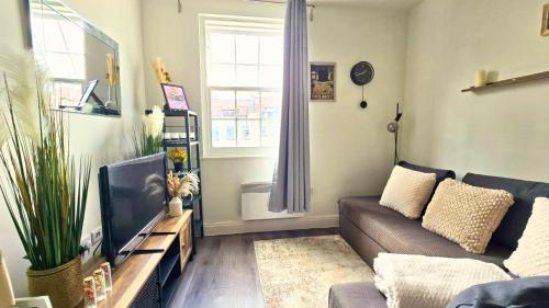 a living room with a couch and a tv at The Bristol Vault in Bristol