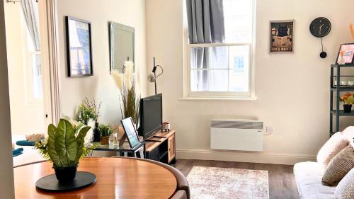 un soggiorno con un tavolo e una TV di The Bristol Vault a Bristol
