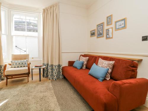 a living room with a orange couch and a chair at Garden flat on The Hoe - Tamar in Plymouth