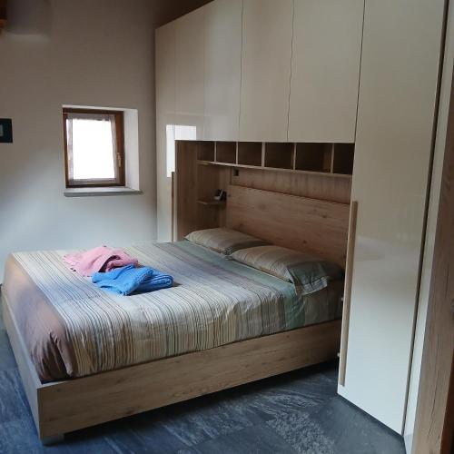 a bedroom with a large bed with a wooden headboard at La mansarda del cervo in Santa Maria Maggiore