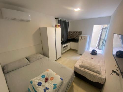 a small room with a bed and a refrigerator at Casa de Cond - Villas de Jacuípe in Camaçari