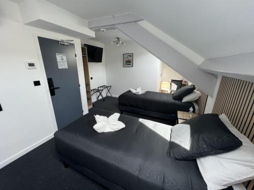 a living room with two beds and a staircase at Hotel Le royal in Tulle