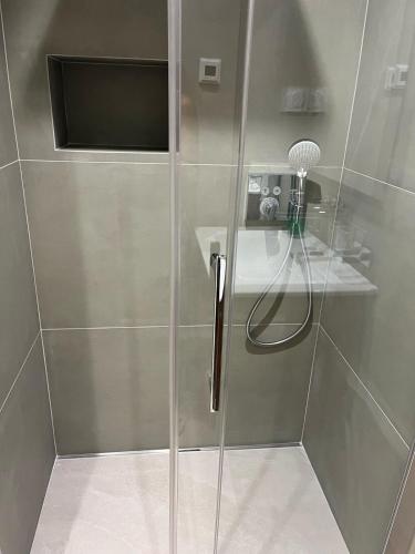 une douche avec une porte vitrée dans une salle de bain dans l'établissement T3 vue mer avec piscine, à Cavalaire-sur-Mer