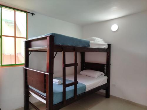 two bunk beds in a room with a window at A 4 Minutos del Malecón con Barril Asador, Ideal para Relajarte y Compartir in Guatapé