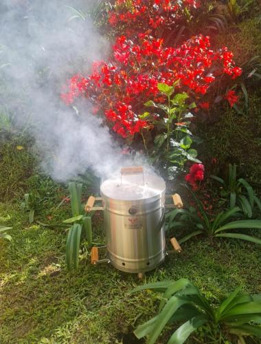 a large pot with smoke next to some flowers at A 4 Minutos del Malecón con Barril Asador, Ideal para Relajarte y Compartir in Guatapé