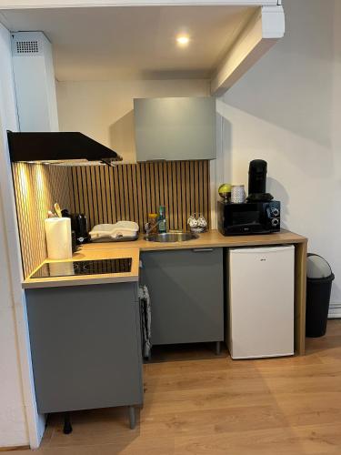 une cuisine avec un évier et un plan de travail dans l'établissement T2 cosy - toit terrasse privé - WiFi - Bergerac, à Bergerac