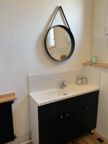 une salle de bain avec un lavabo et un miroir au mur dans l'établissement T2 cosy - toit terrasse privé - WiFi - Bergerac, à Bergerac