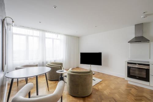 Una sala de estar con una mesa y sillas y un televisor. en Luxurious Residence in Chelmsford City, With Full Sky Channels, en Chelmsford