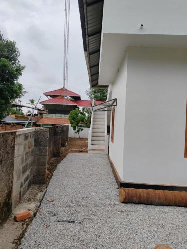 a white building with a walkway in front of it at Sapphire Haven in Varkala