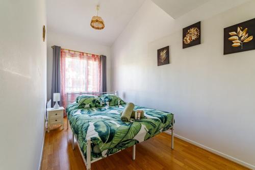 une chambre avec un lit avec une couette verte dans l'établissement A Deux pas de la Mer, à Bandol