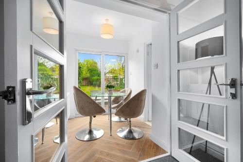 a dining room with a glass table and chairs at Stylish Four Bedroom House - Garden - Parking - Great Barr 110F in Birmingham