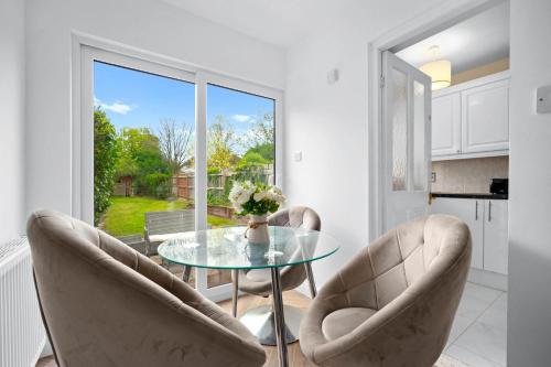 a dining room with a glass table and two chairs at Stylish Four Bedroom House - Garden - Parking - Great Barr 110F in Birmingham