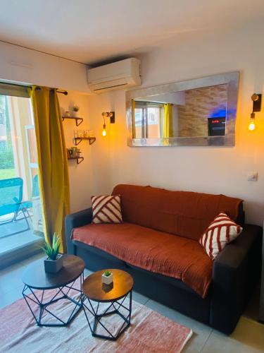 un salon avec un canapé et deux tables dans l'établissement Golf Juan Riviera, piscine, 5min plage, à Vallauris