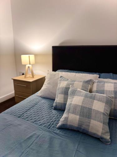 a bedroom with a bed with two pillows and a lamp at Chic Trafford Apartment, Private Underground Parking, Fast Wi-Fi, Self Check-in Anytime, 5 mins to Old Trafford Stadium in Manchester