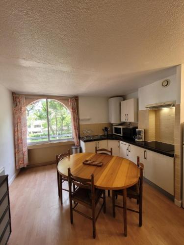 une cuisine et une salle à manger avec une table en bois dans l'établissement Appartement 2 pièces - un petit coin de paradis, à La Grande Motte